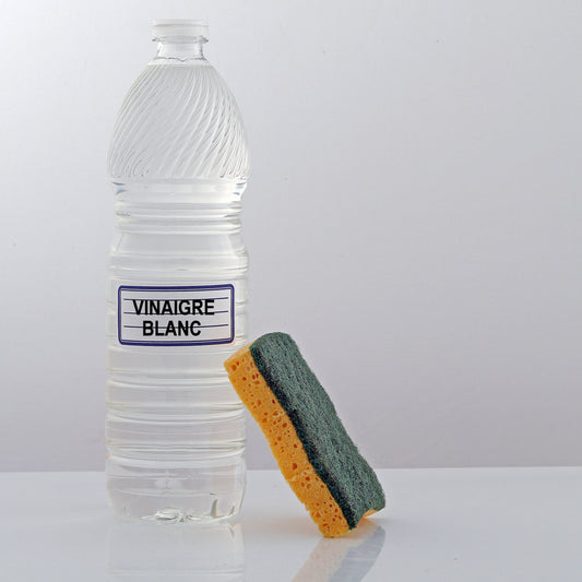 Une bouteille de vinaigre ménager avec une éponge